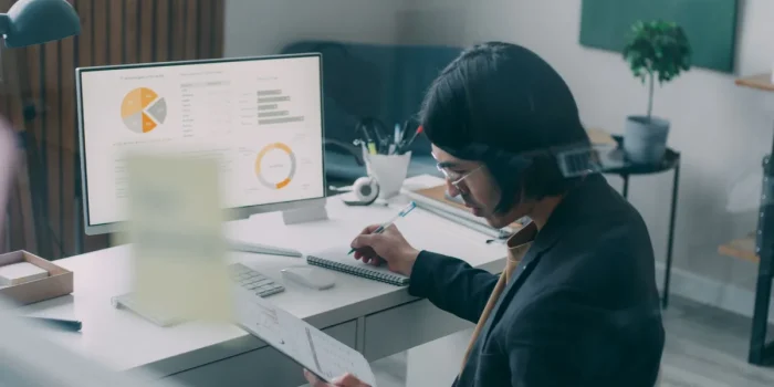 Personne travaillant sur un ordinateur avec un tableau de bord d'automatisation et des métriques affichés à l'écran