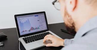 Mains analysant des graphiques de conversion et des métriques KPI sur un écran d'ordinateur portable