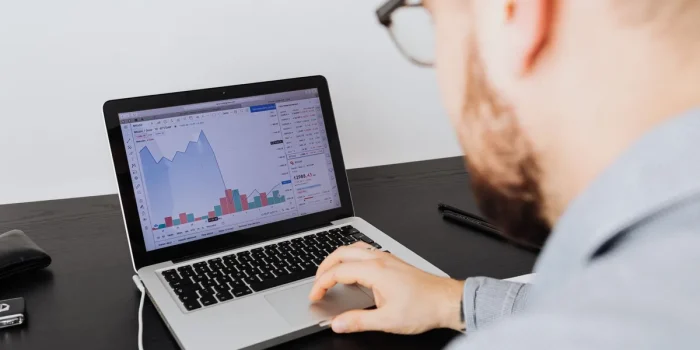 Mains analysant des graphiques de conversion et des métriques KPI sur un écran d'ordinateur portable