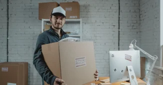 Entrepôt e-commerce avec rangées de colis et boîtes organisés, main d'un employé saisissant un article