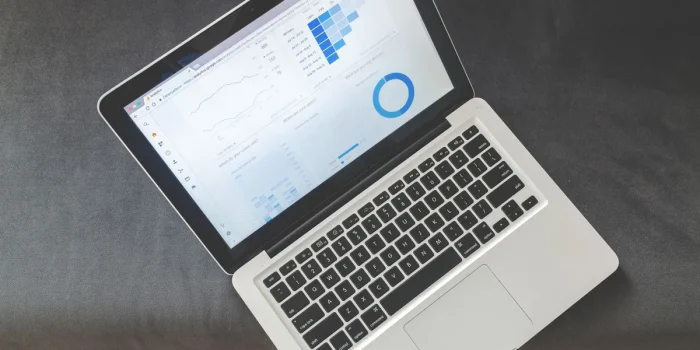 Mains tapant sur un clavier devant des graphiques d'analyse SEO et des métriques de performance