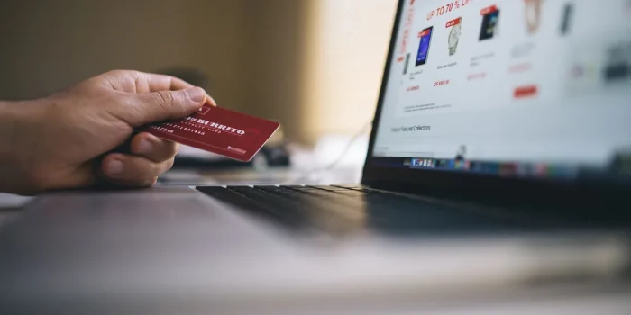 Personne consultant des avis clients et des notes en étoiles sur un écran d'ordinateur portable