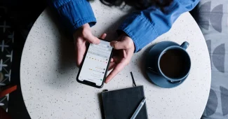 Main d'une personne pointant vers une évaluation cinq étoiles sur un écran de téléphone