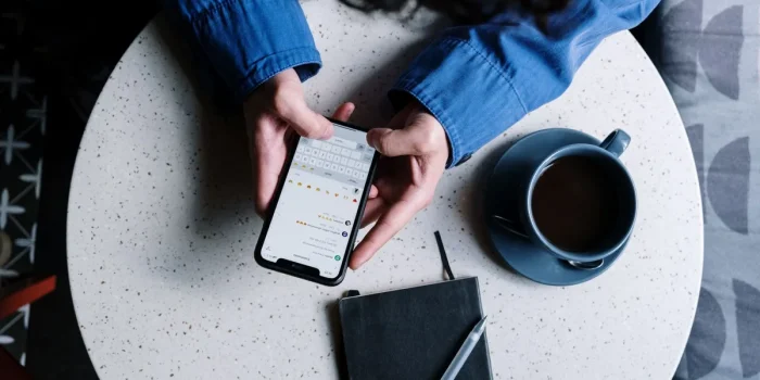 Main d'une personne pointant vers une évaluation cinq étoiles sur un écran de téléphone