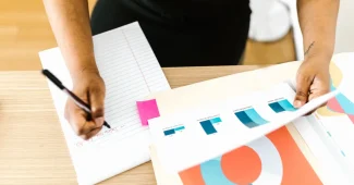 Mains triant et organisant des documents et fiches de données sur un bureau pour audit qualité.