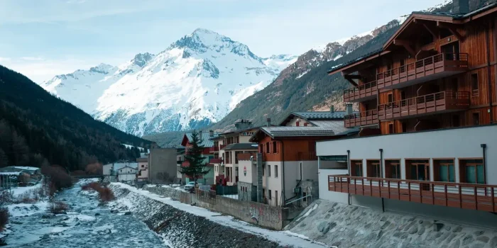 Village alpin enneigé dans les montagnes avec chalets et domaines skiables visibles
