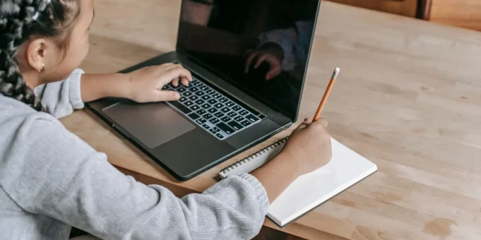 Étudiant en train de relire et corriger un devoir sur son ordinateur portable à un bureau