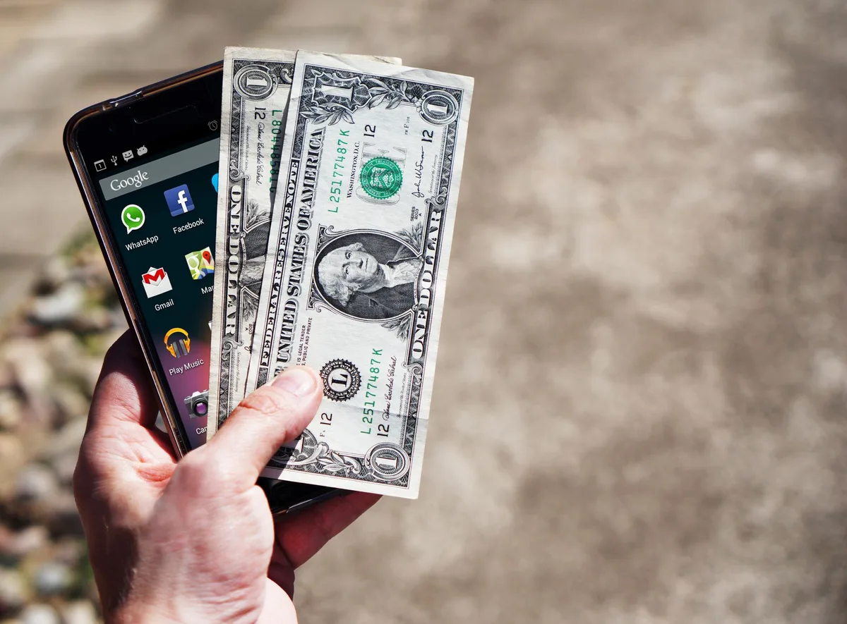 Personne consultant l'application bancaire sur son téléphone pour localiser un distributeur