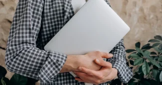 Main d'une personne consultant des avis clients et des étoiles de notation sur un écran d'ordinateur portable