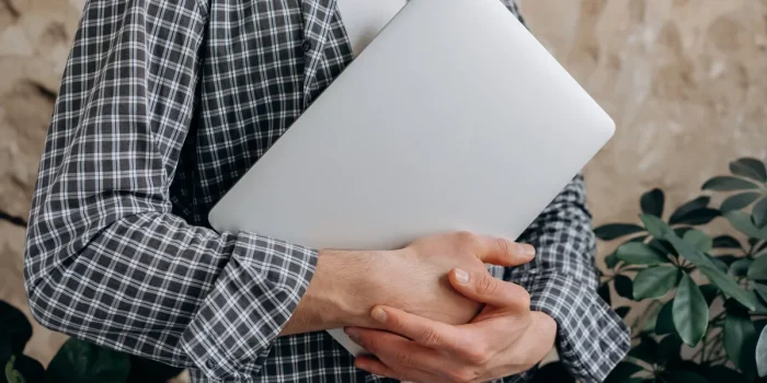 Main d'une personne consultant des avis clients et des étoiles de notation sur un écran d'ordinateur portable