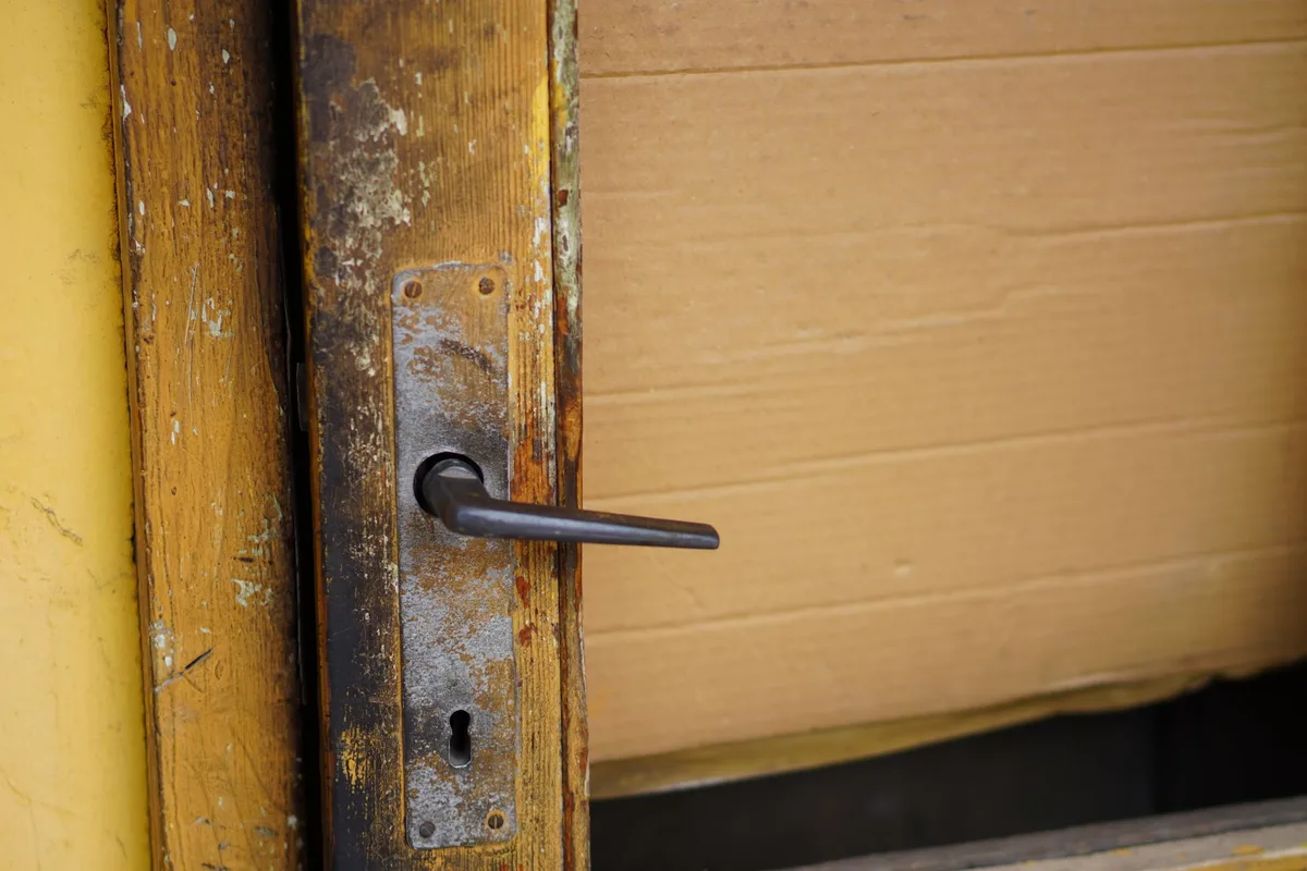 Gros plan d'une serrure de porte vieillie et endommagée, symbole de vulnérabilité d'accès