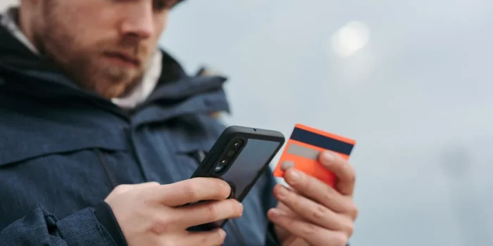 Main tenant une main scrollant sur un téléphone affichant des évaluations en étoiles et avis clients
