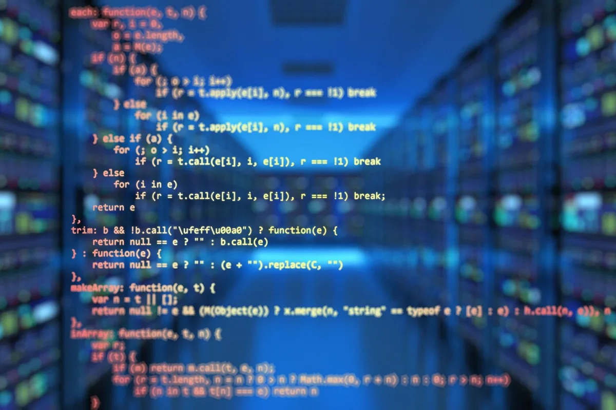 Poste de développeur avec écran affichant du code, clavier et cahier