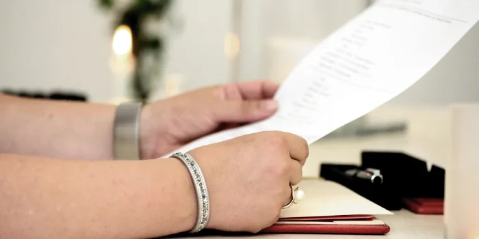 Bureau de notaire en pleine journée avec contrat de mariage et mains anonymes consultant des documents