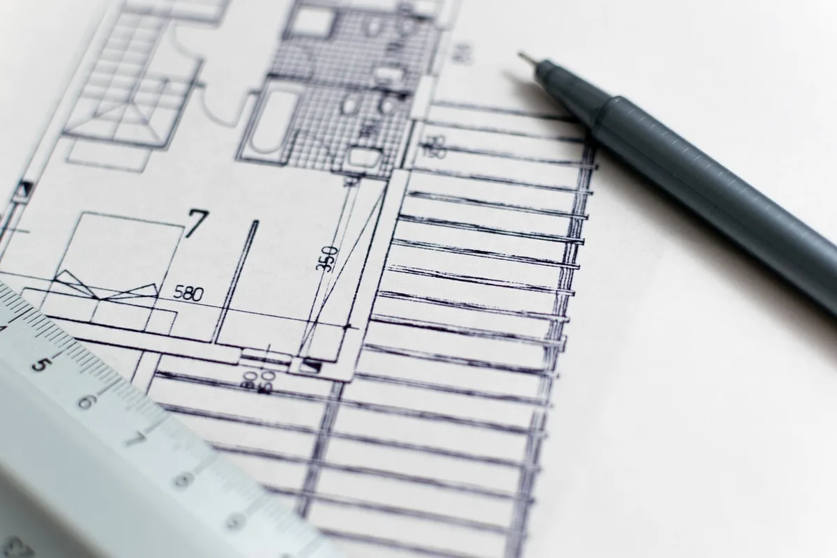 Personnes préparant un plan à l'échelle sur une table avec meubles en papier