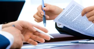 Documents de succession, relevés bancaires et actes de propriété organisés sur un bureau avec une calculatrice