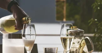 Mains anonymes échangeant une gourde inox et un tote bag recyclé sur une table de bureau