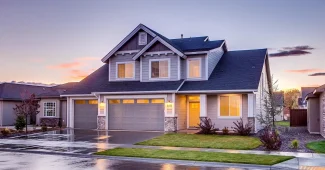 Mains tenant un acte de vente et des clés de maison sur un bureau ensoleillé avec plans