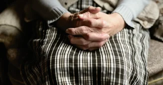 Bureau lumineux avec mains anonymes et dossiers, évoquant l'emploi des seniors