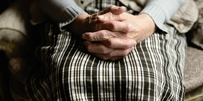 Bureau lumineux avec mains anonymes et dossiers, évoquant l'emploi des seniors