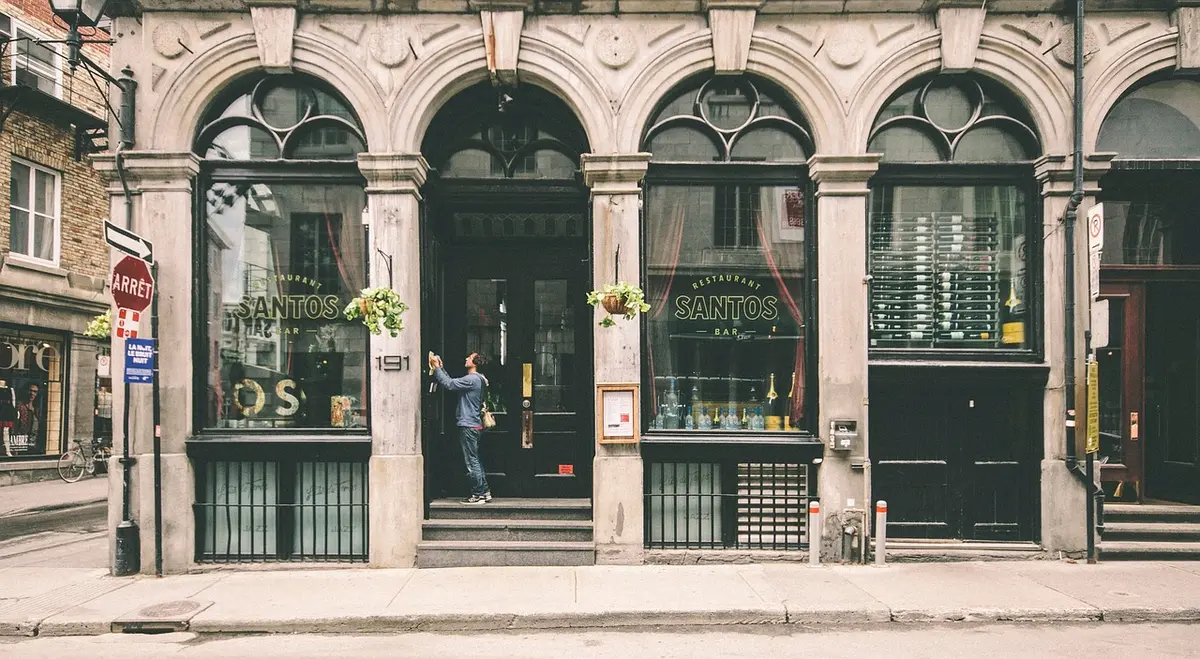 Façade de bar sportif dans une rue animée, visibilité et accès piéton