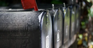 Main d'une personne pointant vers un écran d'ordinateur affichant des dossiers de boîte de réception et des indicateurs