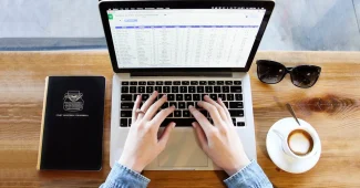 Espace de travail avec ordinateur portable, notes papier et applications numériques symbolisant l'automatisation des tâc