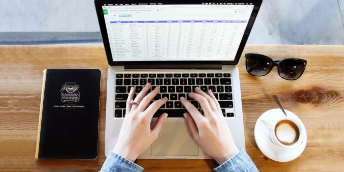 Espace de travail avec ordinateur portable, notes papier et applications numériques symbolisant l'automatisation des tâc
