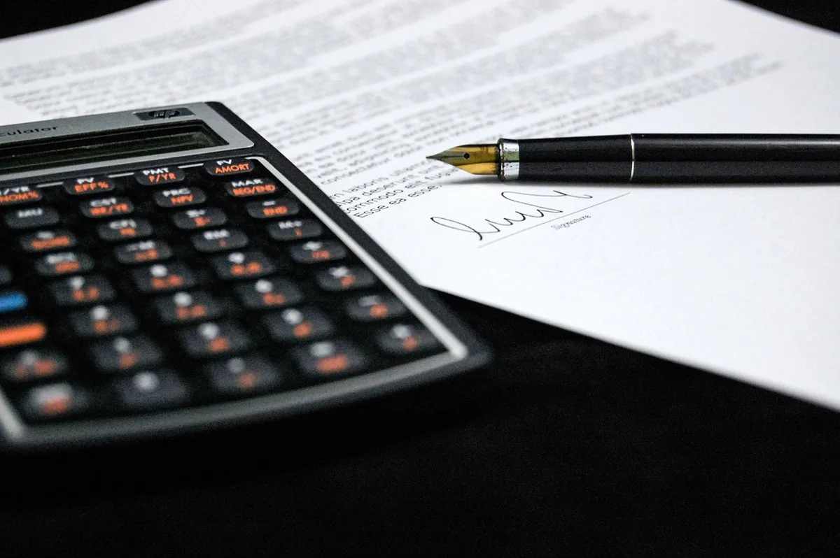 Dossier de candidat locataire et calculatrice sur un bureau