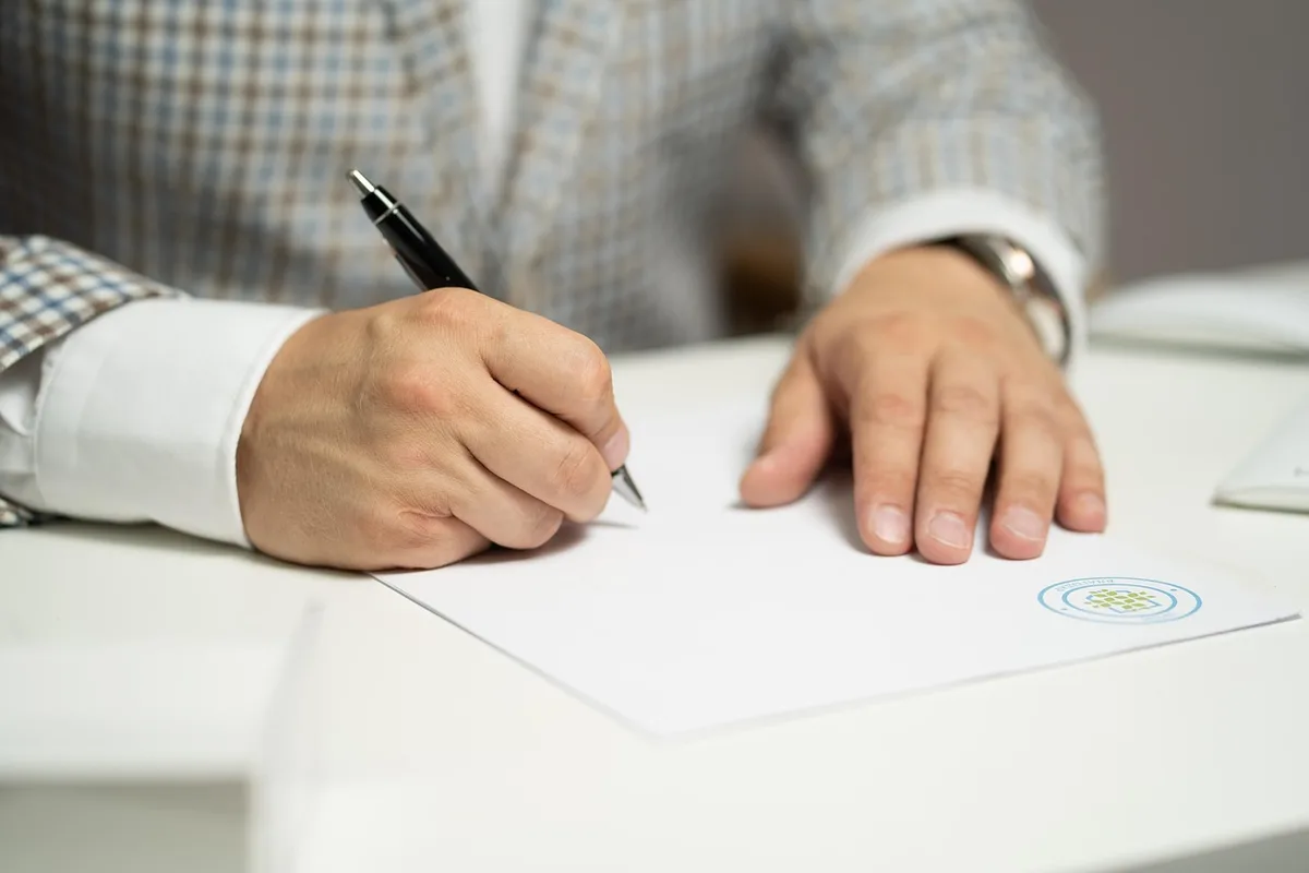 Un huissier rédigeant un procès-verbal lors d'une visite sur place pour constater des faits