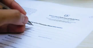 Main d'une personne tenant un smartphone et un bloc-notes, avec des documents sur un bureau, pour documenter une preuve