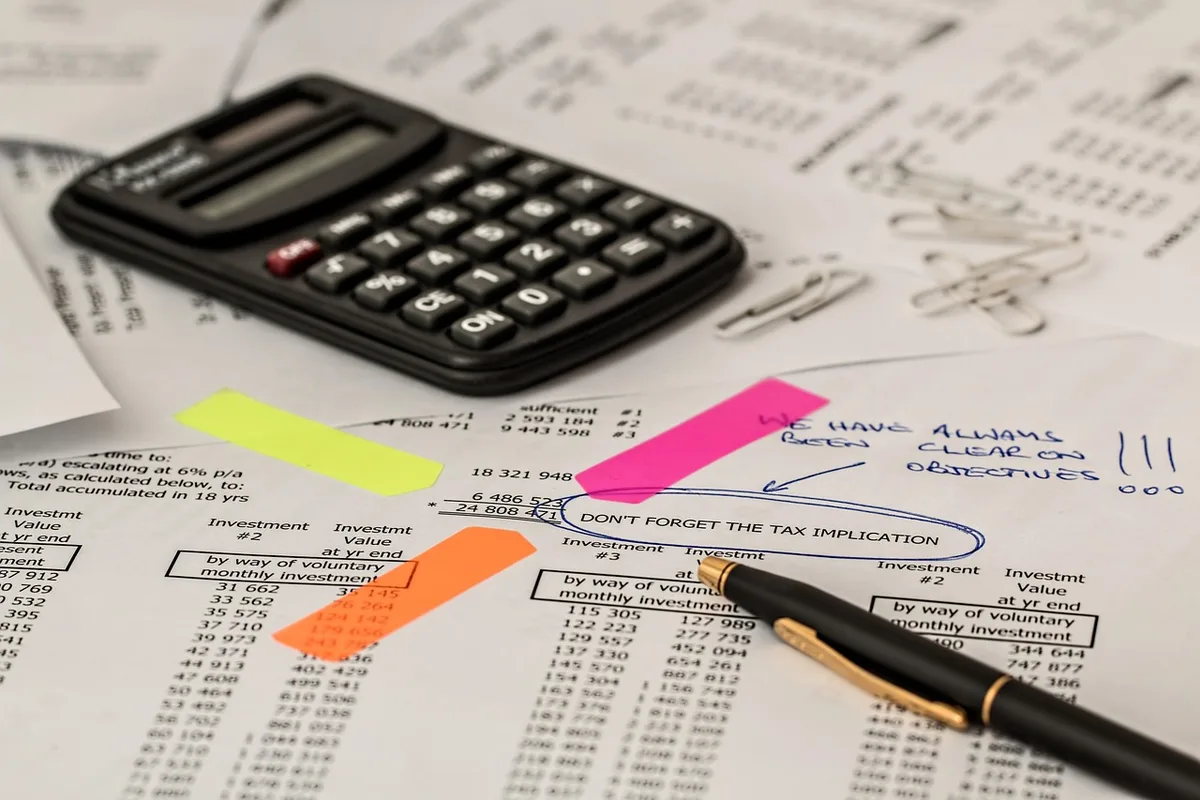 Calculatrice et papiers fiscaux illustrant l'effet de l'inflation sur la base cadastrale