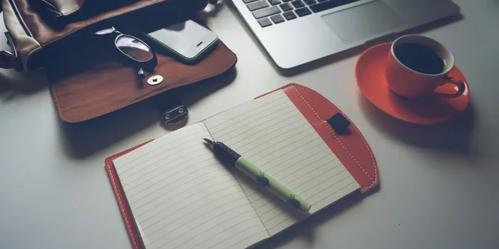 Marketeur à un bureau ensoleillé examinant des graphiques et des notes