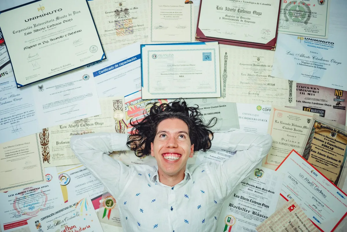 Main tenant un diplôme encadré près d'un bureau clair