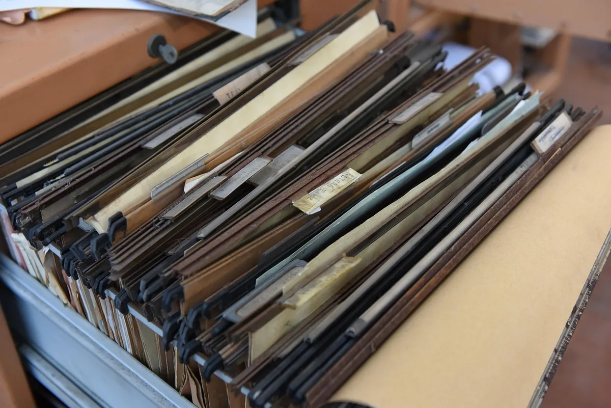 Dossier contenant factures, contrats et preuves de virements sur une table claire