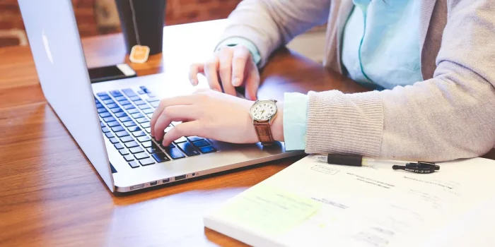 Mains devant un ordinateur et graphiques sur un bureau en plein jour