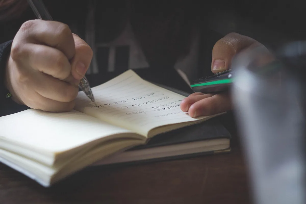 Mains posées sur des papiers juridiques et une calculatrice pour illustrer le rapport de donation