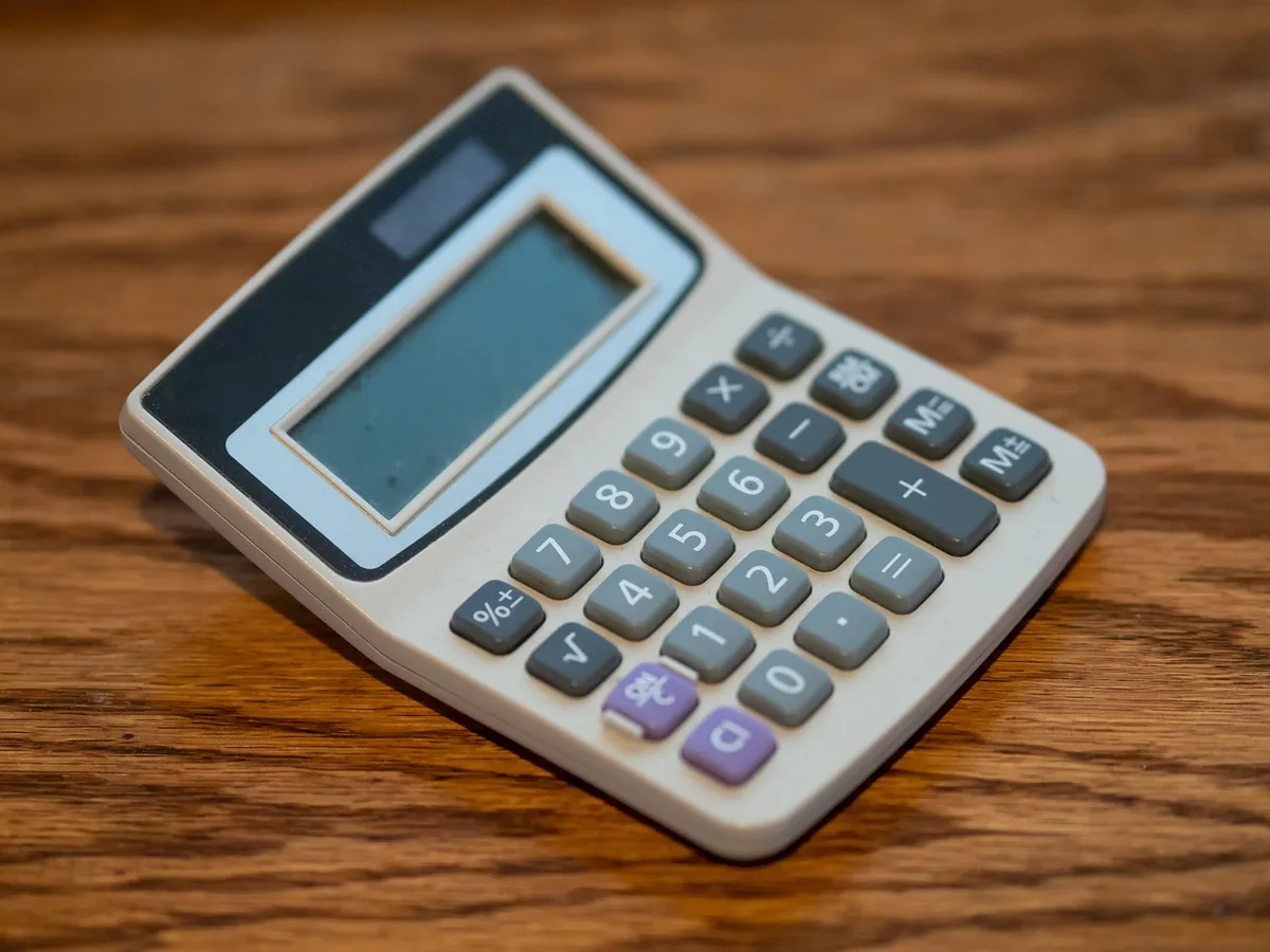 Carnet ouvert et calculatrice sur un bureau pour épargne de précaution