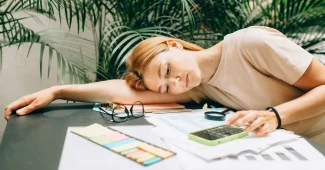 Bureau de jour avec carnet, documents et calculatrice près d'une fenêtre