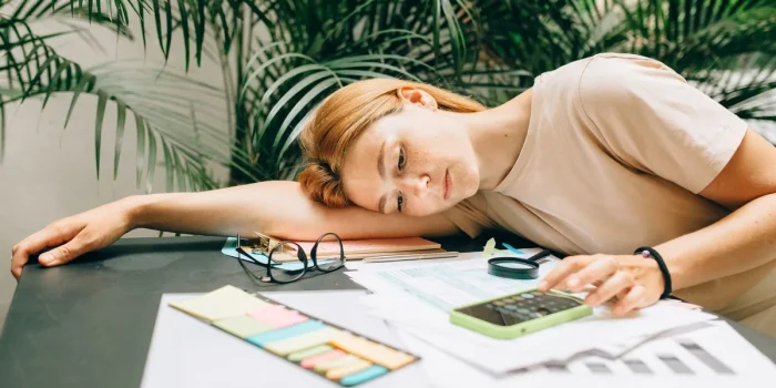 Bureau de jour avec carnet, documents et calculatrice près d'une fenêtre
