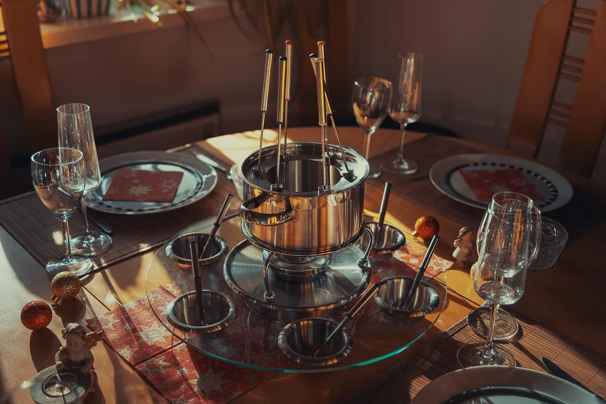 Personne triant des albums et objets personnels sur une table éclairée par la fenêtre